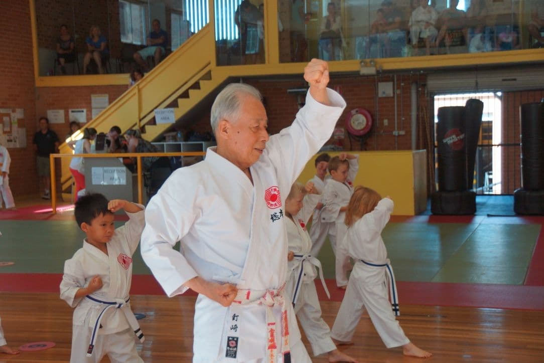Karate instructor leading kids in a class demonstrating focus and discipline