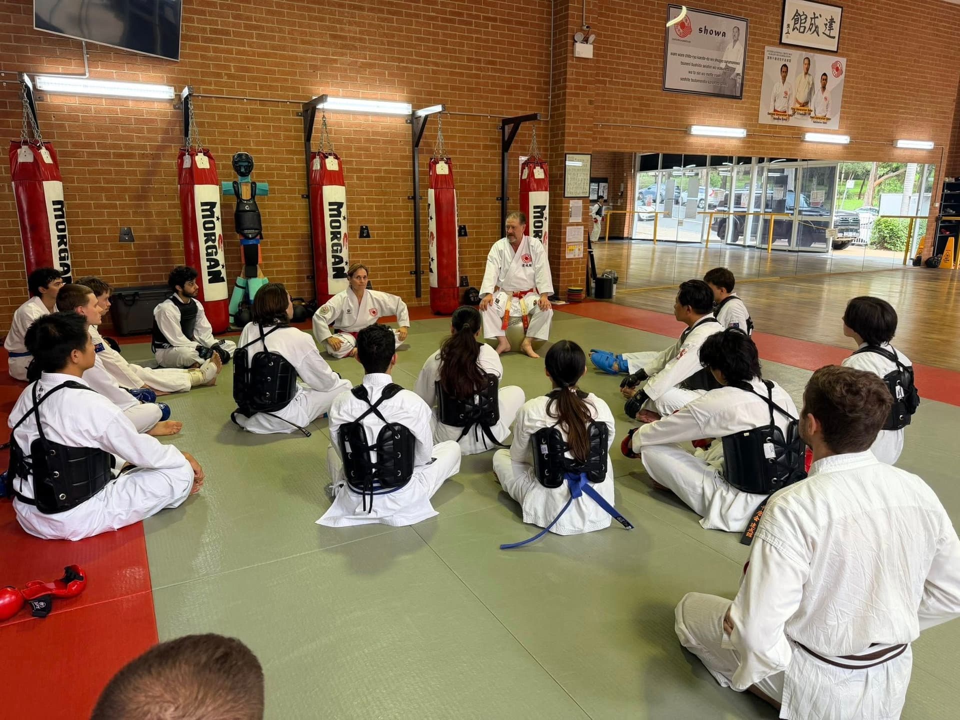 Karate instructor leading group martial arts class with students in dojo training session