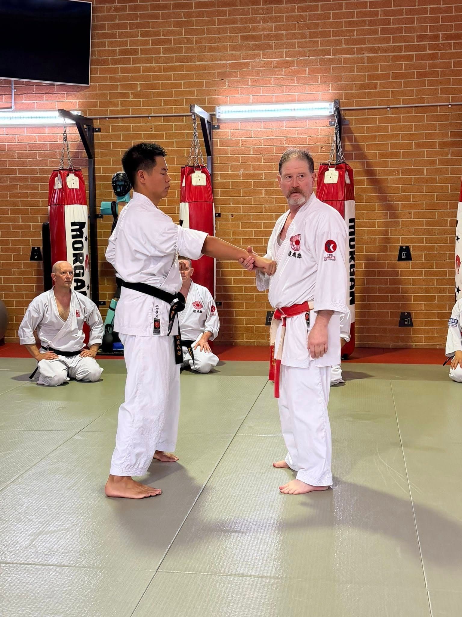 Karate instructor correcting student technique during training session